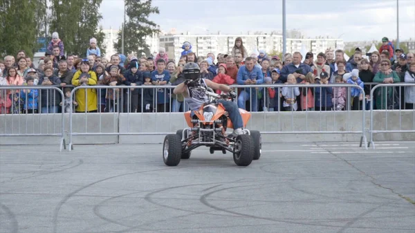 Yekaterinburg, Russia-August, 2019: Man on Quad bike performs tricks. Action. Professional stunt rider on Quad bike performs acrobatic stunts on background of crowd at freestyle show — Stockfoto