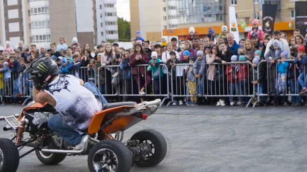 Yekaterinburg, Russia-August, 2019: Man on Quad bike performs tricks. Action. Professional stunt rider on Quad bike performs acrobatic stunts on background of crowd at freestyle show — Stock fotografie