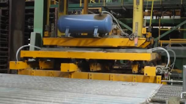 Primo piano del nastro trasportatore e del meccanismo di lavorazione che si muove verso il basso in fabbrica. Filmati delle scorte. Attrezzature professionali nello stabilimento di produzione . — Video Stock