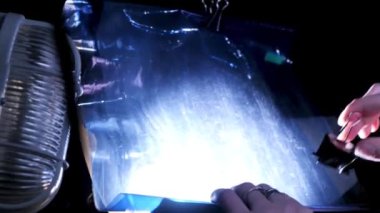 Siyah arka plandaki beyaz, eski moda cam lambanın altındaki mavi plastik örtüyü kapat. Stok görüntüleri. Fotoğraf ve video çekimi için alışılmadık bir arkaplan oluşturuluyor