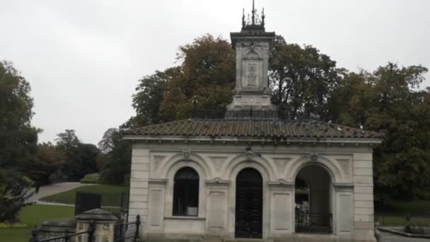 Hermoso pequeño edificio histórico situado en el Hyde Park, Londres, Inglaterra. Acción. Concepto de arquitectura, antiguo edificio blanco frente a verdes árboles y prados . — Vídeo de stock