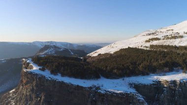 Kışın mavi gökyüzünün arka planında güneş ışığında güzel bir kaya. Vuruldu. Açık kış gününde, büyük doğa manzaraları güçlü güzellikleriyle herkesi büyüleyecektir.