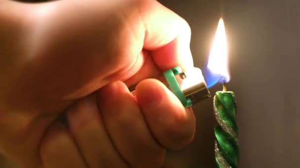 Primo piano dell'uomo che accende la candela di Natale. Concetto. Uomo accende candela lunga vacanza per cena accogliente su sfondo di luci sfocate — Video Stock