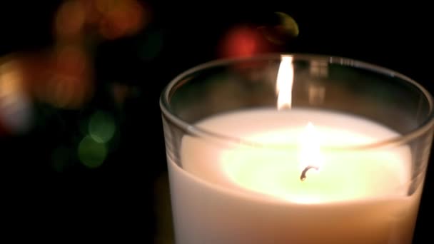 Primo piano di candela festiva su sfondo di luci sfocate. Concetto. Chiaro fuoco sul portacandele che brucia sullo sfondo di luci sfocate colorate festive — Video Stock