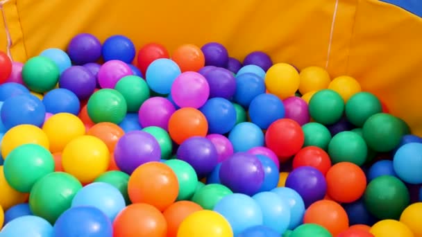 Bolas de plástico de colores en una piscina para niños. Imágenes de archivo. Primer plano de un montón de bolas de colores en una piscina de bolas de juegos infantiles, divertirse concepto . — Vídeo de stock