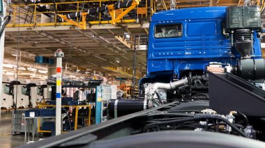 Kamaz kamyon fabrikasında otomobil üretim hattı üretimi. Sahne. Zaman atlaması etkisi, gövdesi asılı endüstriyel arka plan, makine mühendisliği konsepti..