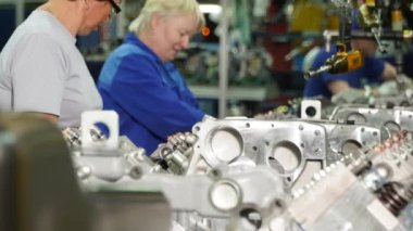 Rusya - Moskova 5 Mart 2020: Motoru monte eden işçilerin bulunduğu bir üretim hattında bulunan pek çok metal detayı kapatın. Sahne. Araba fabrikası, makine mühendisliği konsepti, zaman