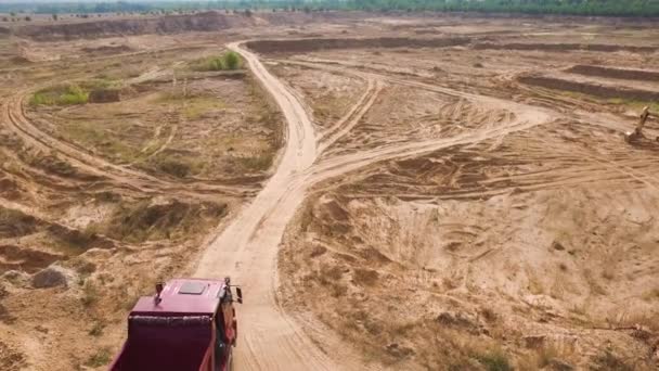 Vyhazovací náklaďák jedoucí na lomovém území. Scéna. Horní pohled na sklápěcí vůz projíždějící oblastí pouště s prašným povrchem v lomu. Těžká přeprava pro lomové operace — Stock video