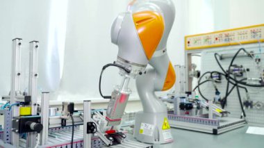 Modern otomatikleştirilmiş el. Sahne. Modern fabrikanın tamamlanmış parçalarını yeniden düzenlemek için otomatik robot kolu. Modern robot teknolojisi iş başında