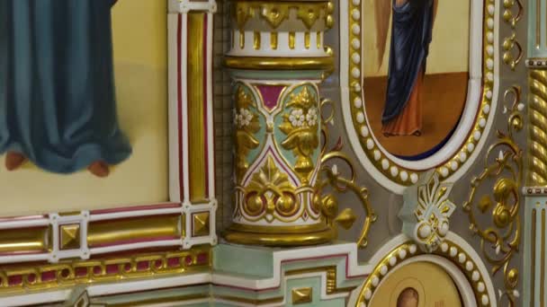ロシア-モスクワ, 2020年3月25日:アイコン、宗教の概念と美しいフレスコ画の壁をカバーする装飾的な正統派教会の内部。ストック映像だ。金材料で覆われた正教会の寺院の壁. — ストック動画