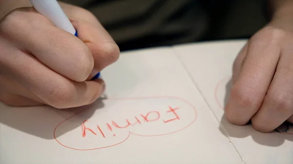 Notas para niños con corazones en cuaderno. Concepto. Primer plano de las palabras de los niños rodeadas de corazón. Niño escribió palabra familia y dibujó corazón —  Fotos de Stock