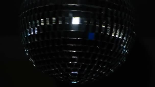Close-up de bola de discoteca no fundo preto. Conceito. A bola de disco gira no escuro e reflete a luz. Bola de disco de vidro bonita no escuro no feriado — Vídeo de Stock