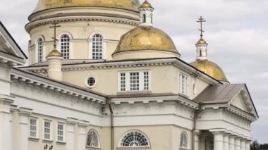 Altın kubbeli Hristiyan Kilisesi 'nin güzel mimari cephesi. Stok görüntüleri. Bulutlu gökyüzünün arka planında altın kubbeler olan Kilisenin beyaz duvarları