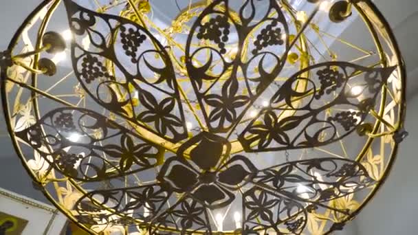 Hermosa araña dorada en la Iglesia. Imágenes de archivo. Panikadilo es la lámpara principal del templo y símbolo de la Iglesia Celestial. Patrones de calado lámparas de araña de la iglesia con velas mirada divina — Vídeo de stock