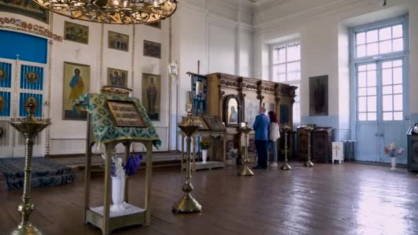 Hombre y mujer en el icono de la Iglesia Cristiana. Imágenes de archivo. El hombre le dice a la mujer creyente sobre el icono mientras conduce una gira en la Iglesia Cristiana — Vídeos de Stock