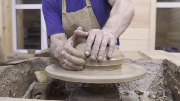 Potter forms plate out of clay. Stock footage. Mens hands of professional Potter form container of clay on Potters wheel. Pottery workshop — Stock Video