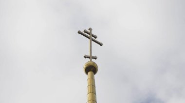 Kule cephesine yakın çekim ve kilise kubbesine çapraz geçiş. Stok görüntüleri. Bulutlu gökyüzünün arka planında Kilisenin altın kubbesinde güzel haçlar yükselir.