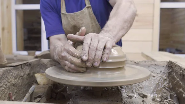 Potter forme une assiette en argile. Images d'archives. Mens mains de professionnel Potter forme récipient d'argile sur la roue Potters. Atelier de poterie — Photo