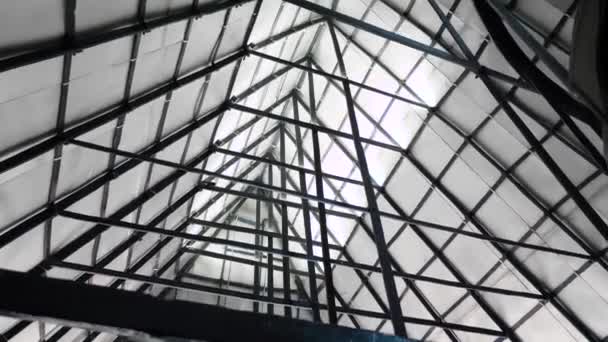 Trojúhelníková střecha se železnými trámy. Záběry ze skladu. Spodní pohled na kovovou konstrukci trojúhelníkové střechy s mnoha nosníky. Pod trojúhelníkovým obloukem kovové konstrukce — Stock video