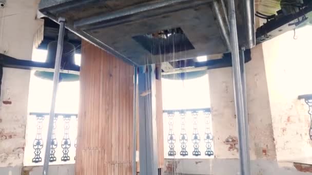 A templom harangtornyában. Készletfelvétel. A harangtorony mechanizmusa a templomtoronyban. Sok kötél kapcsolódik több haranghoz a toronyban. — Stock videók