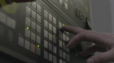 Endüstriyel ekipmanların kontrol panelinin düğmelerine bir el basar. Stok görüntüleri. Erkek eli fabrika panelinde düğmeye basarken yan görünüm.