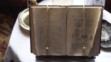 Masanın üzerinde eski biyoloji kitabı açık. Başla. Biyoloji ve İngilizce metinler üzerine resimli kitap standda duruyor. Eski kitap klasik müzede sergileniyor.