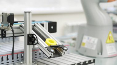 Modern atölyede 3D yazıcı tarafından üretilen sarı nesneyi kapat. Sahne. Robot mekanizmasının teknolojik arka planı bir detay oluşturuyor, bilim konsepti.