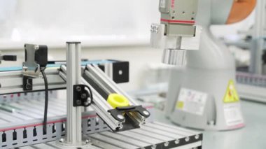 Modern atölyede 3D yazıcı tarafından üretilen sarı nesneyi kapat. Sahne. Robot mekanizmasının teknolojik arka planı bir detay oluşturuyor, bilim konsepti.