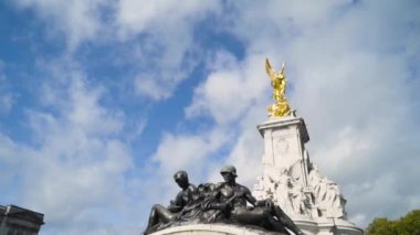 Mavi arka planda heykelleri olan güzel anıtın alt manzarası. Başla. Çeşitli pozlarda insan heykelleri olan anıt, yüksek mevkilerdeki Altın Kadın 'ın ayaklarında duruyor.