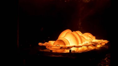 Metalurji fabrikasındaki metal işleme detaylarını kapatın. Sahne. Sıcak atölyedeki bir fırının içindeki metal parçalarının üretimi..