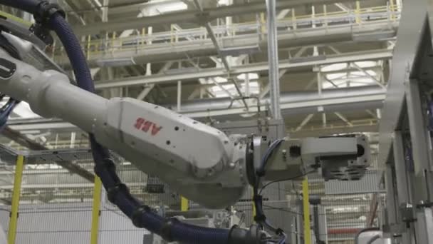 Rússia - Moscou 15 de março de 2020: Fechar o braço robótico automático inserindo detalhes no mecanismo na linha de produção de uma fábrica de automóveis. Cena. Conceito de equipamento e maquinaria profissional . — Vídeo de Stock
