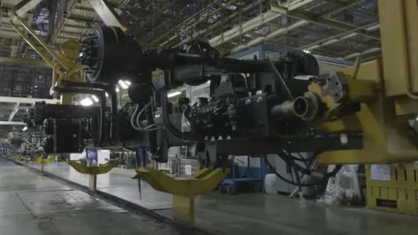 Proceso de producción de camiones mineros pesados en la fábrica. Escena. Transmisión de camiones volquete en el transportador industrial en el taller de una planta automotriz . — Vídeo de stock