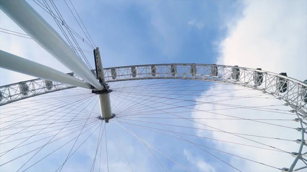 Vue du bas de la grande roue moderne sur fond bleu ciel. L'action. La grande roue ne fonctionne pas par temps clair. Nombreuses lignes connectées dans la grande roue — Photo