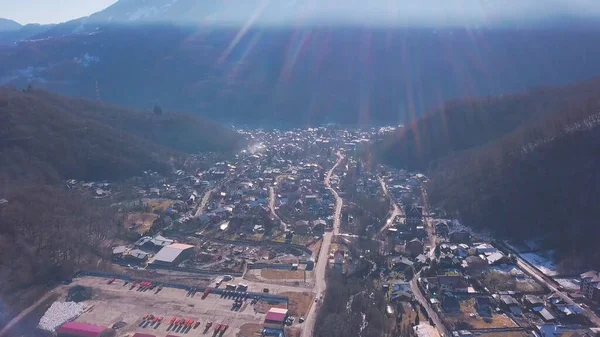 山の中で町を照らす太陽の美しい光線のトップビュー。クリップ。晴れた日には山の中で開発された町 — ストック写真