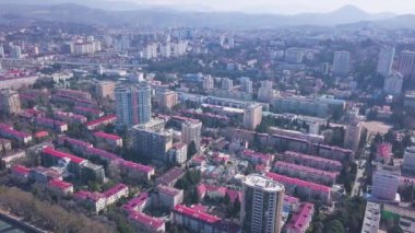 Dağların arka planında, kıyıya yakın modern şehrin güzel manzarası. Şarjör. Bir tarafta deniz, diğer tarafta dağların bulunduğu gelişmiş büyük şehir manzarası.