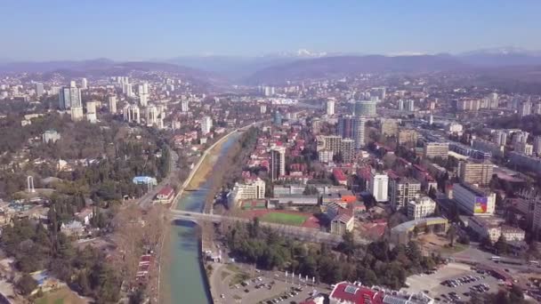 Panorama van grote stad met rivier op de achtergrond van bergen. Een knip. Top uitzicht op de rivier stroomt door de hele stad gelegen in de bergvallei — Stockvideo