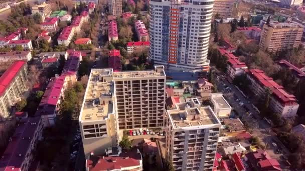 Maisons de ville modernes avec des toits rouges sous les rayons du soleil. Clip. Vue de dessus des immeubles résidentiels urbains de grande hauteur avec des toits rouges éclairés par le soleil couchant — Video