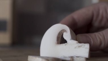 Şampiyon parçaları, mantarları bıçakla, yemek pişirmeyle, vejetaryenlikle, beslenme konseptiyle eşit parçalara ayırın. Başla. Bıçak bıçağı mutfakta şampiyonları kesiyor..