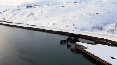 Gemi enkazından sonra yıkık dökük teknelerle kışın karlı sahil manzarası. Görüntü. Barents Denizi kıyısında batık balıkçı tekneleri.