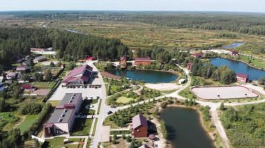 Yazın bulutlu gökyüzünün altında köy, orman, göletler, nehirler ve tarlaların bulunduğu kırsal alan manzarası. Görüntü. Yaşamak için ekolojik yeri olan çarpıcı bir manzara..