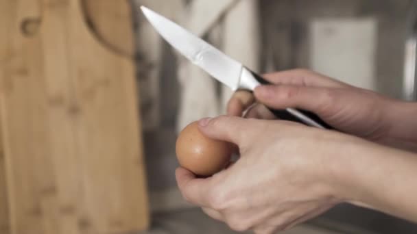 Primer plano de las manos de mujer rompiendo el huevo con un cuchillo y poniendo la clara cruda y la yema en el puré de papas, concepto de cocción. Acción. Puré de papas con huevos en un plato profundo en la cocina . — Vídeos de Stock