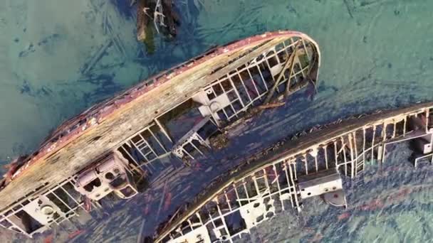 De rostiga resterna av det gamla lastfartyget på grunt vatten, ovanpå flygplanet. Fotografering. Skelett på ett förstört havsgående fartyg nära stranden. — Stockvideo
