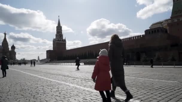 As pessoas visitam a Praça Vermelha em Moscou, Rússia. Acção. Conceito de viagem e turismo, visão traseira da mãe e filha menina andando perto do famoso Kremlin . — Vídeo de Stock