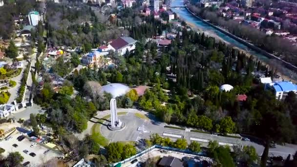 Blick von oben auf das Denkmal in der Touristenstadt im Sommer. Clip. Denkmal in Form eines hohen Bogens befindet sich im Zentrum des Parks der Touristenstadt — Stockvideo