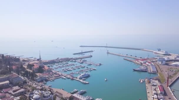 Vista superior de la bahía con yates cerca de la ciudad. Clip. Puerto marítimo y bahía con yates cerca de costa de gran ciudad turística sobre fondo de horizonte marítimo — Vídeo de stock