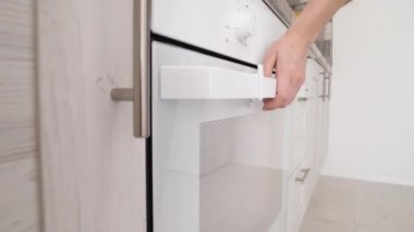 Kadın fırını açıyor ve içine tabak koyuyor. Başla. Ev fırınına peynir serpiştirilmiş yakın çekim. Yemek pişirme kavramı