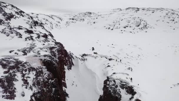 Vista superior del grupo de personas en el paso de montaña en invierno. Filmación. Panorama de turistas que viajan entre rocas de montaña en invierno — Vídeos de Stock