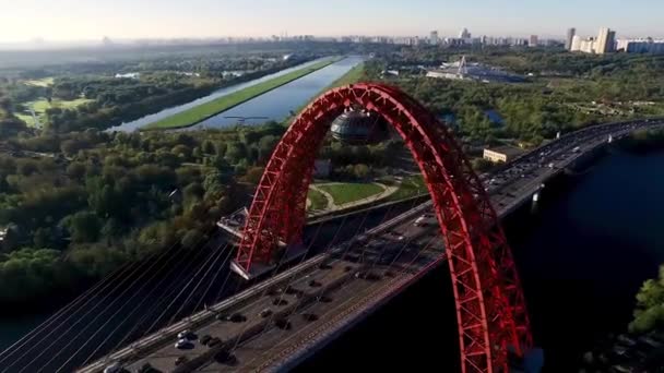 Αεροφωτογραφία της Μόσχας με ένα σύγχρονο καλώδιο παρέμεινε γέφυρα, Ρωσία, αρχιτεκτονική και ορόσημα έννοια. Σκηνή. Πετώντας πάνω από το ποτάμι και κρεμαστή γέφυρα με κόκκινη γιγάντια αψίδα. — Αρχείο Βίντεο