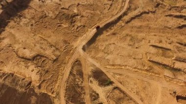 Kırsal tozlu yolda giden damperli kamyonlar, ulaşım konsepti. Sahne. Bir yaz günü kırsal alanda kirli bir yolda giden kamyonun en üst görüntüsü..