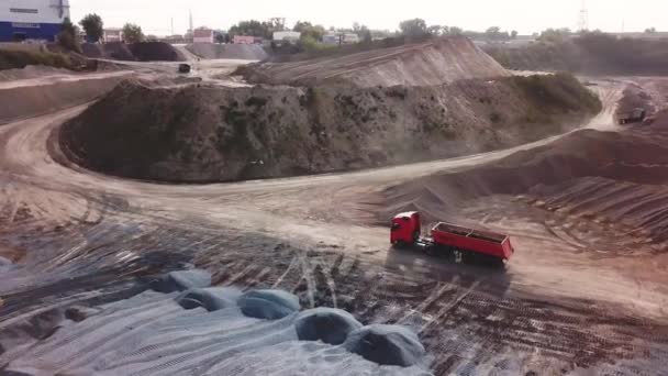 Voler au-dessus d'une carrière de pierre avec des camions lourds et des machines. Images d'archives. Vue aérienne du paysage industriel avec excavatrices et camions . — Video